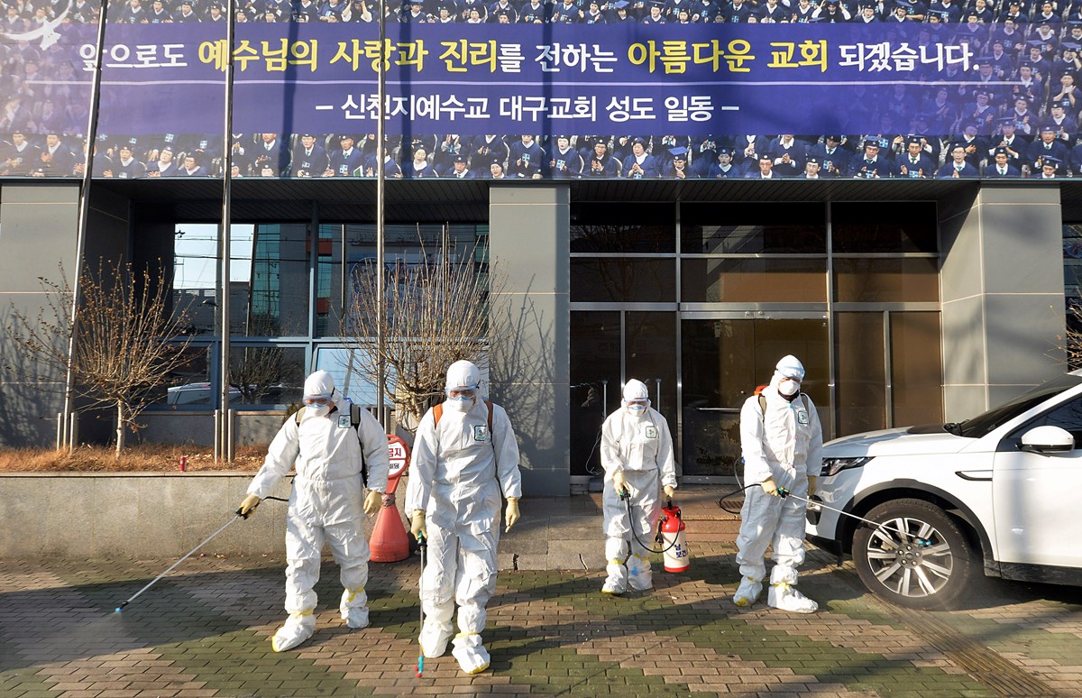 Workers wearing protective gears spray disinfectant against the coronavirus in front of a Shincheonji church in Daegu, South Korea.