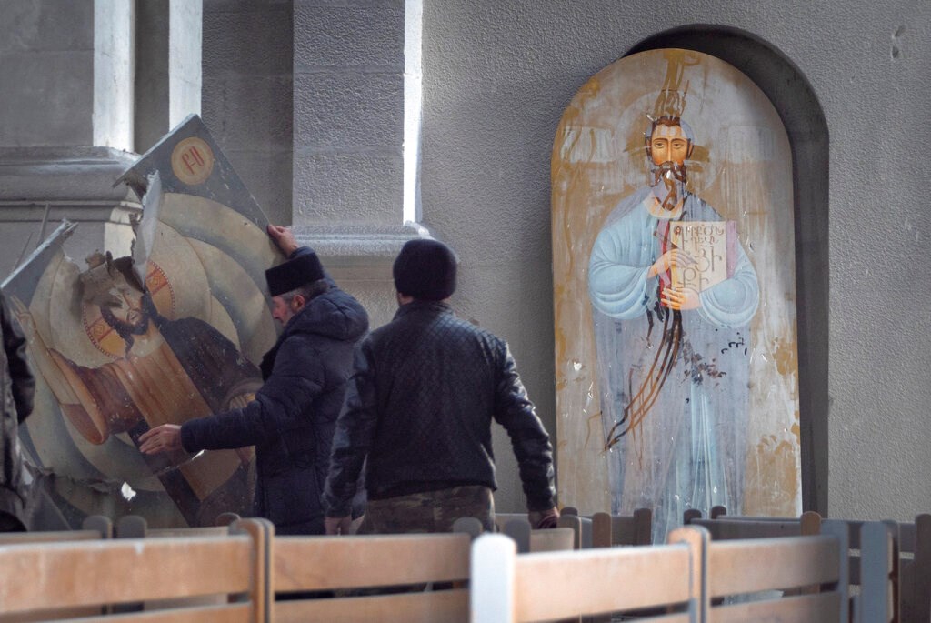 Men lift an icon in the Holy Savior Cathedral damaged by shelling during a military conflict, in Shushi, outside Stepanakert, self-proclaimed Republic of Nagorno-Karabakh on October 8.