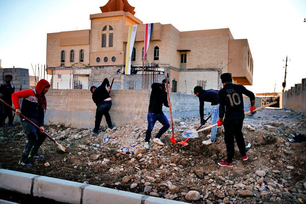 People fix a street destroyed during clashes against Islamic State militants in Qaraqosh, Iraq, on February 23.