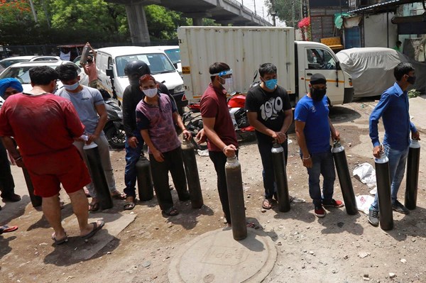 Orang-orang antre untuk mengisi ulang oksigen di tabung silinder di New Delhi, India, pada 23 April. Banyak korban tewas di rumah sakit di ibu kota India di tengah dugaan bahwa pasokan oksigen yang rendah menjadi penyebabnya.