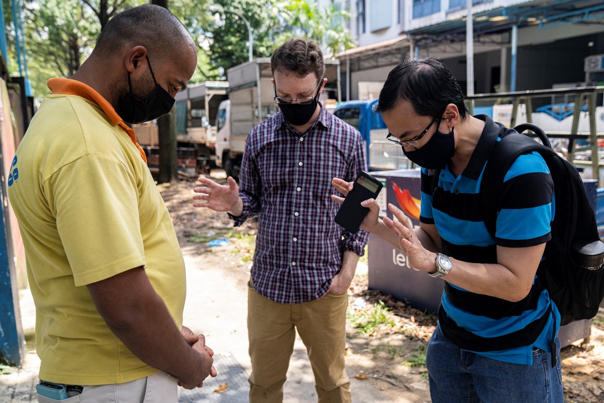 Pastor Guoliang Wong (right) and Thomas Franks (middle) pray together with Francis Xavier (left), a Christian migrant worker outside a factory-converted dormitory in Singapore in April 2020. Pastor Guoliang Wong (right) and Thomas Franks (middle) pray together with Francis Xavier (left), a Christian migrant worker outside a factory-converted dormitory in Singapore in April 2020.