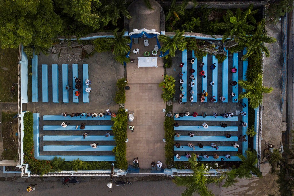 Parishioners attend a mass on the grounds next to an earthquake-damaged cathedral in Les Cayes, Haiti, on Sunday, August 22, 2021, eight days after a 7.2 magnitude earthquake hit the area.