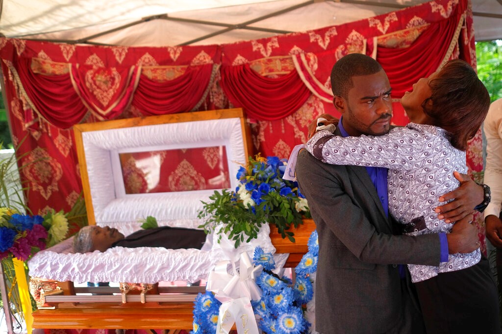 The son and mother of Baptist church minister Andre Tessono, who was killed during the 7.2 magnitude earthquake that hit the area eight days ago, mourn during his funeral in the Picot neighborhood in Les Cayes, Haiti, Sunday, Aug. 22, 2021.