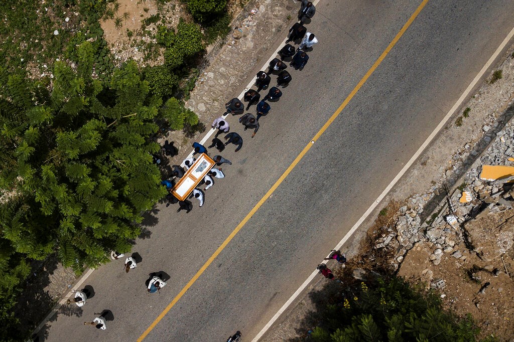 The coffin with the body of Baptist church minister Andre Tessono, who was killed during the 7.2 magnitude earthquake that hit the area 8 days ago, is carried to the cemetery during his funeral in the Picot neighborhood in Les Cayes, Haiti, Sunday, Aug. 22, 2021.