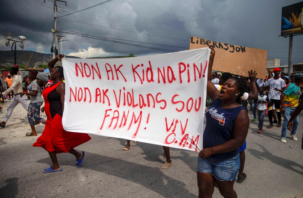 Haitian protesters carry a banner with a message that reads in Creole: "No to kidnappings, no to violence against women! Long live Christian Aid Ministries," demanding the release of kidnapped missionaries, in Titanyen, north of Port-au-Prince, Haiti, on Tuesday, October 19, 2021.