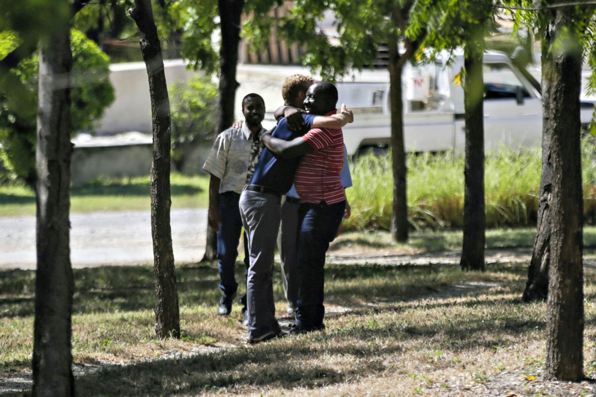 People hug at the Christian Aid Ministries headquarters in Titanyen, north of Port-au-Prince, Haiti, on Thursday, December 16, 2021, after 12 hostage missionaries kidnapped two months ago were finally released.