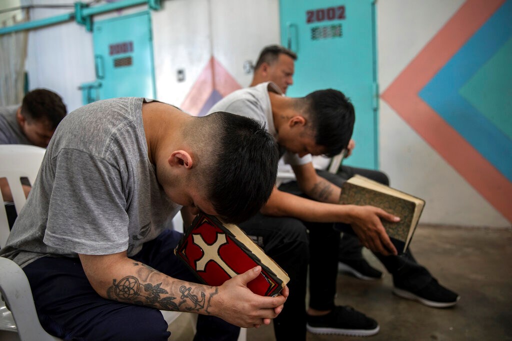 Prisoners pray with their Bibles inside an evangelical cellblock at the prison in Pinero, Santa Fe province, Argentina on Nov. 18, 2021.