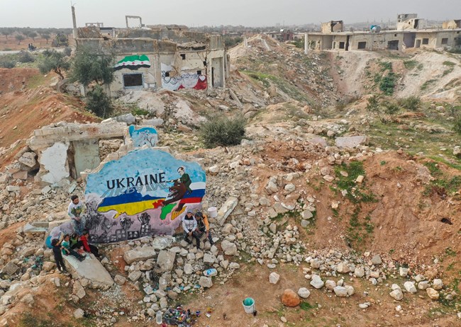 Une peinture murale réalisée par des artistes syriens pour protester contre l’opération militaire russe en Ukraine, au milieu des destructions dans la ville de Binnish, tenue par les rebelles, dans la province d’Idlib, au nord-ouest de la Syrie, le 24 février 2022.