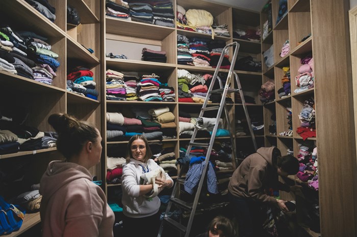 Baptist women organize clothing to donate to those in need.  In a nearby warehouse, they collect and sort humanitarian aid from Poland.