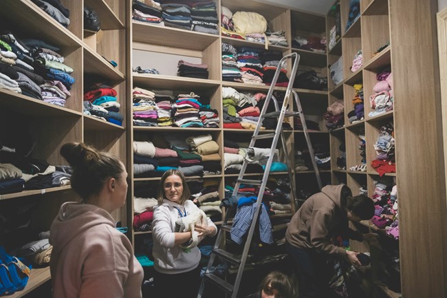 Mujeres bautistas organizan la ropa donada para las personas en necesidad. En un almacén cercano, reúnen y organizan la ayuda humanitaria que llegó desde Polonia.
