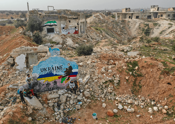 Un mural pintado por artistas sirios en protesta contra la operación milistar rusa en Ucrania, en medio de la destrucción en la localidad de Binish tomada por un grupo de rebeldes, en la provincia Idlib al noroeste de Siria, el 24 de febrero de 2022.