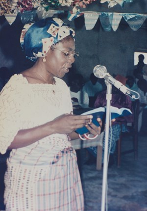 Hannah Oyama, a Mbembe teacher, reads from a newly published Mbembe New Testament, 1985