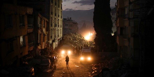 People walk among the rubble from destroyed buildings in Antakya (Antioch), Turkey.