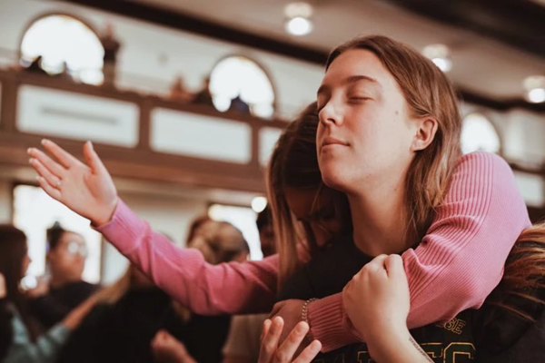 Asbury Revival 2023: Ella Blacey and Lauren Powell pray during a worship service at Asbury University.