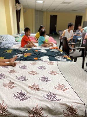 Children sit and listen to worship at the Delhi Relief facility.