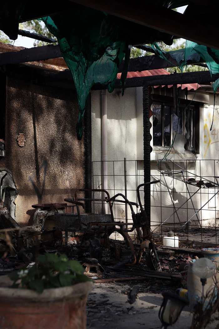 Telhado derretido e destroços queimados na parte externa de uma casa, em Kfar Aza.