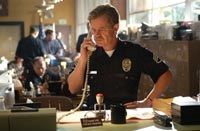 Mooney (William H. Macy) works the phones at the police station