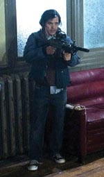 John Leguizamo wielding this film's prop of choice—a big gun