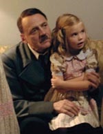 The Fuhrer sits with one of the Goebbels