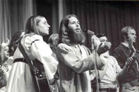 Frisbee (center) singing at a service