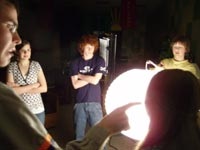 Teacher Erik Woodard explains lighting methods to students Jill Cromwell, Justin Phillips, and Andrew Cromwell