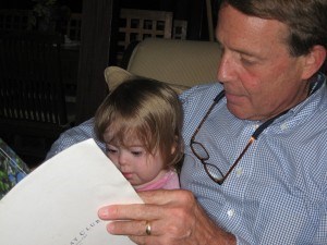 Penny reading a legal document with her Pop Pop at age 2