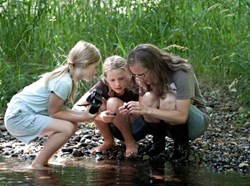 Leah's kids, Maya and Bryn, and A Rocha's intern Audrey explore the wonder of a river.