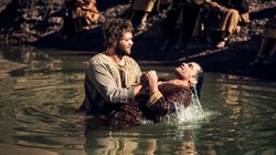 Thomas (Jóhannes Haukur Jóhannesson) baptizes Stephen (Reece Ritchie).