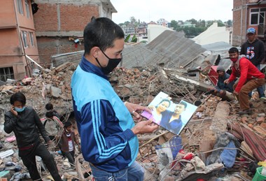 A survivor of Swayambu church collapse shows photo of fellow church member who died.