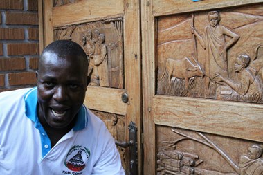 Tour guide and site historian Ben Tenywa poses in front of a door at the Catholic Martyrs' Shrine at Namugongo. The door depicts the young men, who were tortured and murdered for their faith in 1886. Pope Francis visits the shrine this week.  