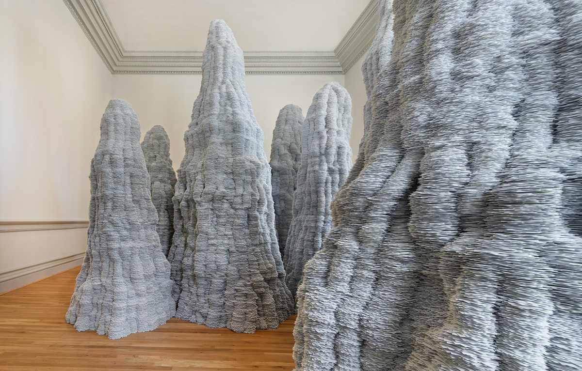The ten fairy chimneys and hoodoos in Tara Donovan’s “Untitled” are made from about a million index cards.
