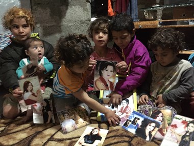 Refugee children from Sinjar display photos of their sister killed by ISIS. Refugee children from Sinjar display photos of their sister killed by ISIS.
