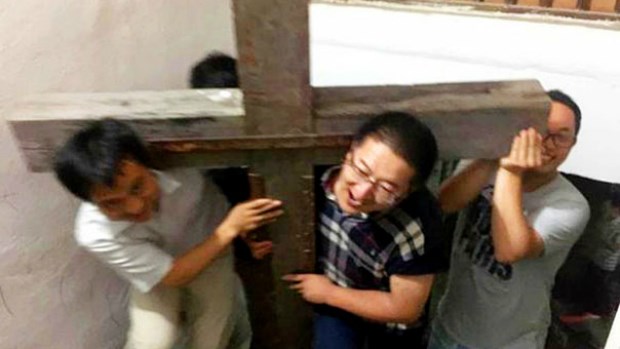 Zhang Kai (center) helps carry a wooden cross at Xialing Church, hours before his arrest.