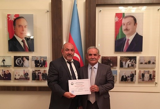 Rasim Khalilov (left), chairman of the Bible Committee, holds the new certificate of registration.