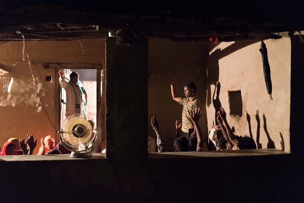 New believers gather for evening prayer at a tribal home in Rajasthan.