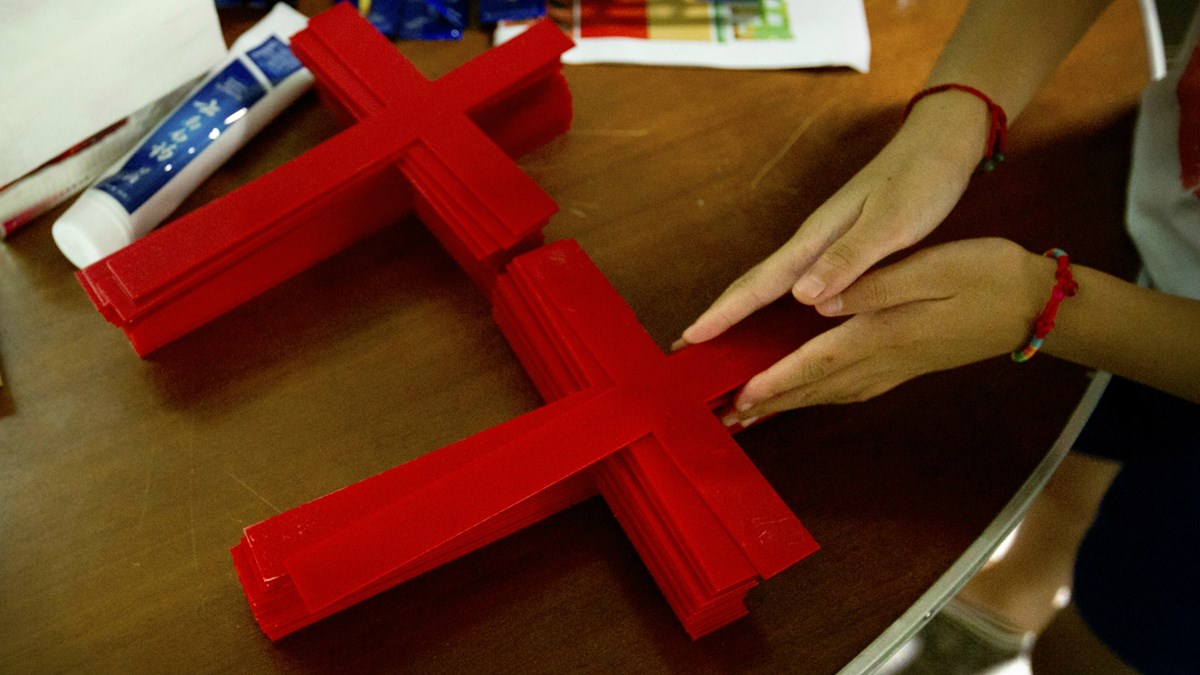 A Protestant church member in Zhejiang arranges crosses used in worship. A Protestant church member in Zhejiang arranges crosses used in worship.