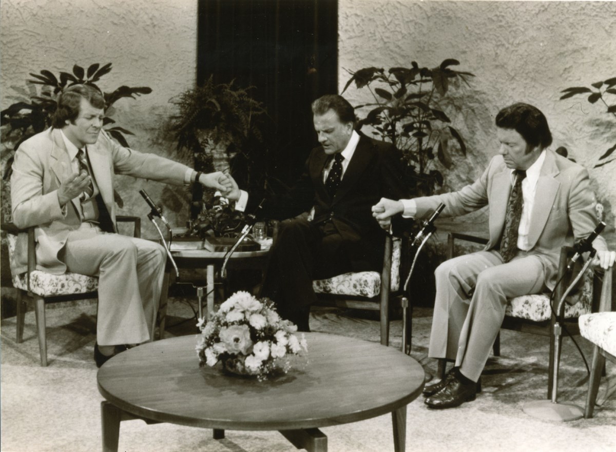 David Mainse prays with Billy Graham and evangelist John Wesley White.