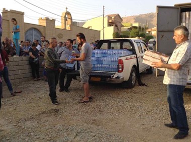 Displaced Iraqi Christians receive aid at St. Qardakh church in al-Qosh.