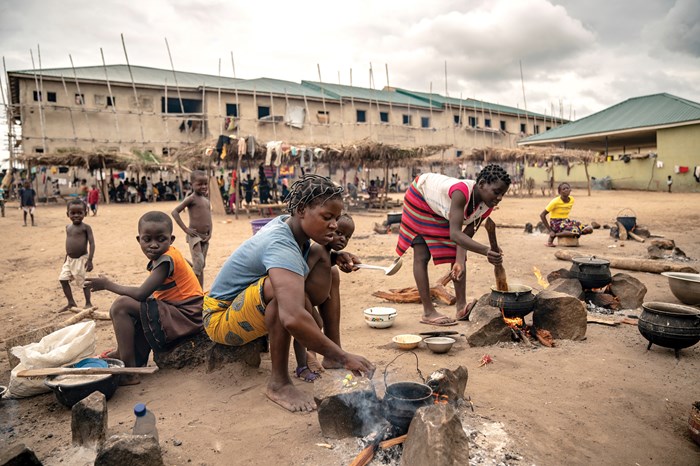At one of Benue’s newest camps for displaced farmers, mothers cook a meager lunch while children gather under thatch trellises in an attempt to maintain their schooling. The Makurdi c­­­amp is so crowded, the men sleep outside unless it rains.
